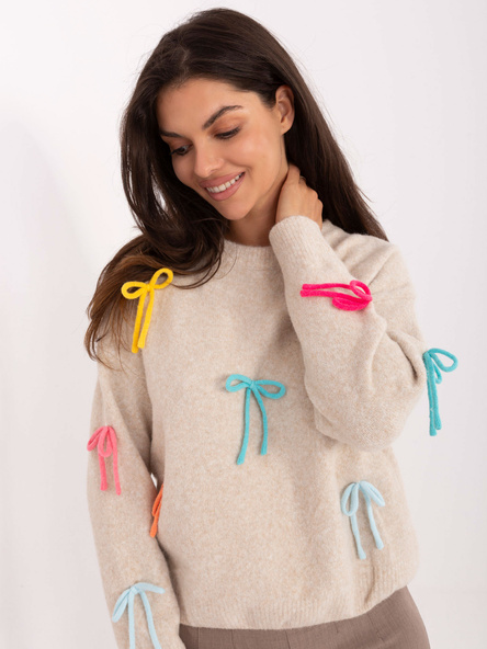 Hellbeige Pullover mit bunten Schleifen.