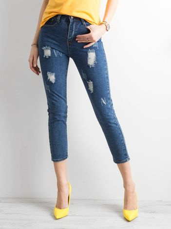 Dunkelblaue Ankle Jeans mit Rissen.