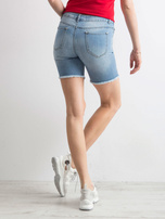 Blaue Jeansshorts mit Aufnähern.