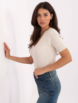 Helle beige, enganliegende Rippensweater.