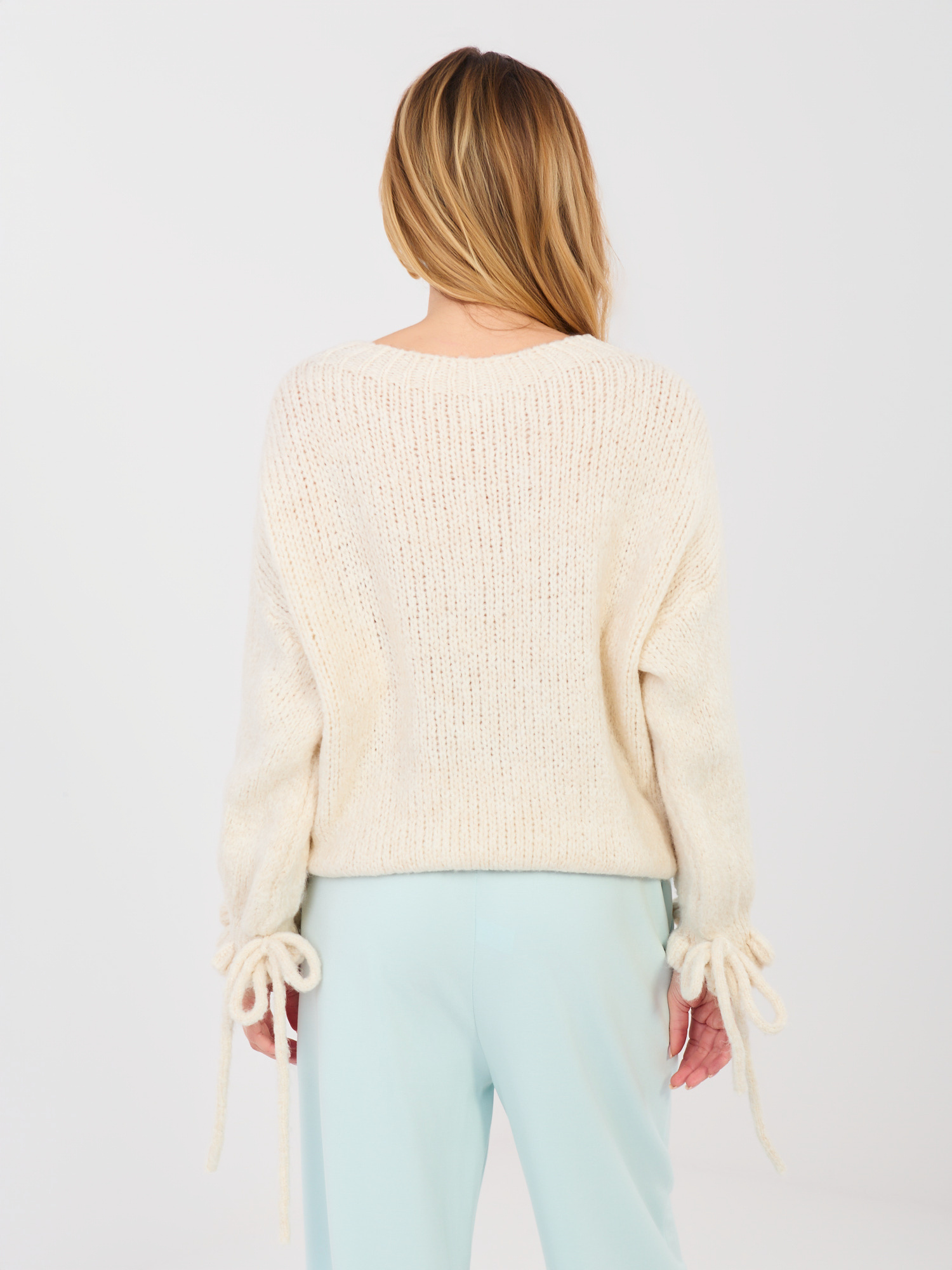 Pastelowy sweter z wiązaniami przy rękawach