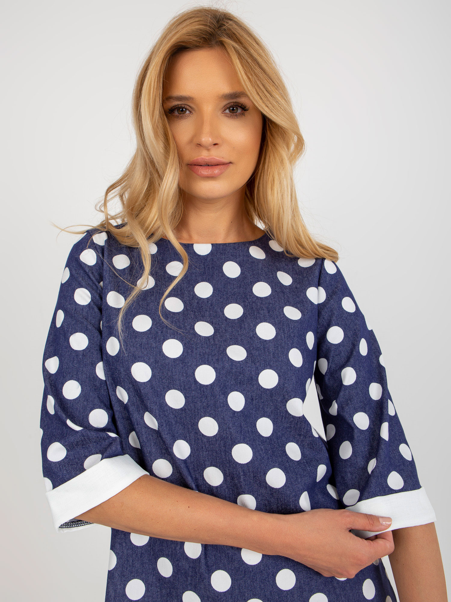Dunkelblaue Bluse mit Punkten und 3/4-Ärmeln.