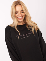 Black cotton blouse with an appliqué.