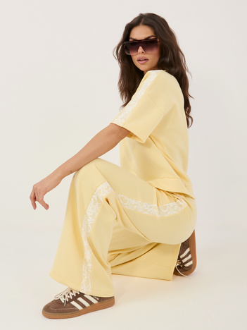 Jasnożółte dresowe spodnie z koronkowymi lampasami