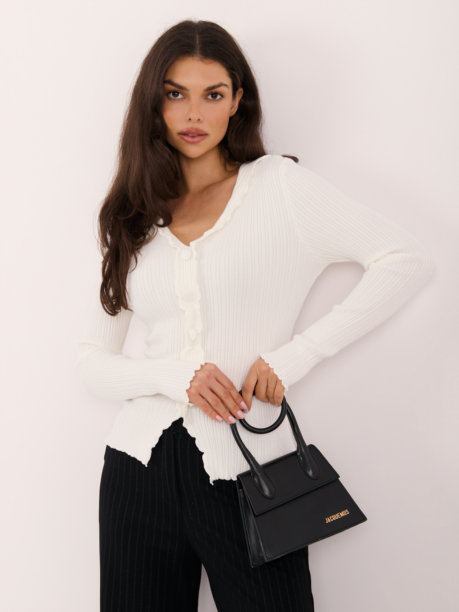 Ecru ribbed sweater with decorative buttons.