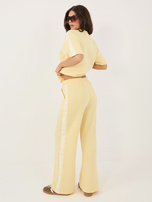 Jasnożółte dresowe spodnie z koronkowymi lampasami