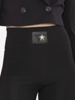 Schwarze Damenleggings mit dekorativem Aufnäher.