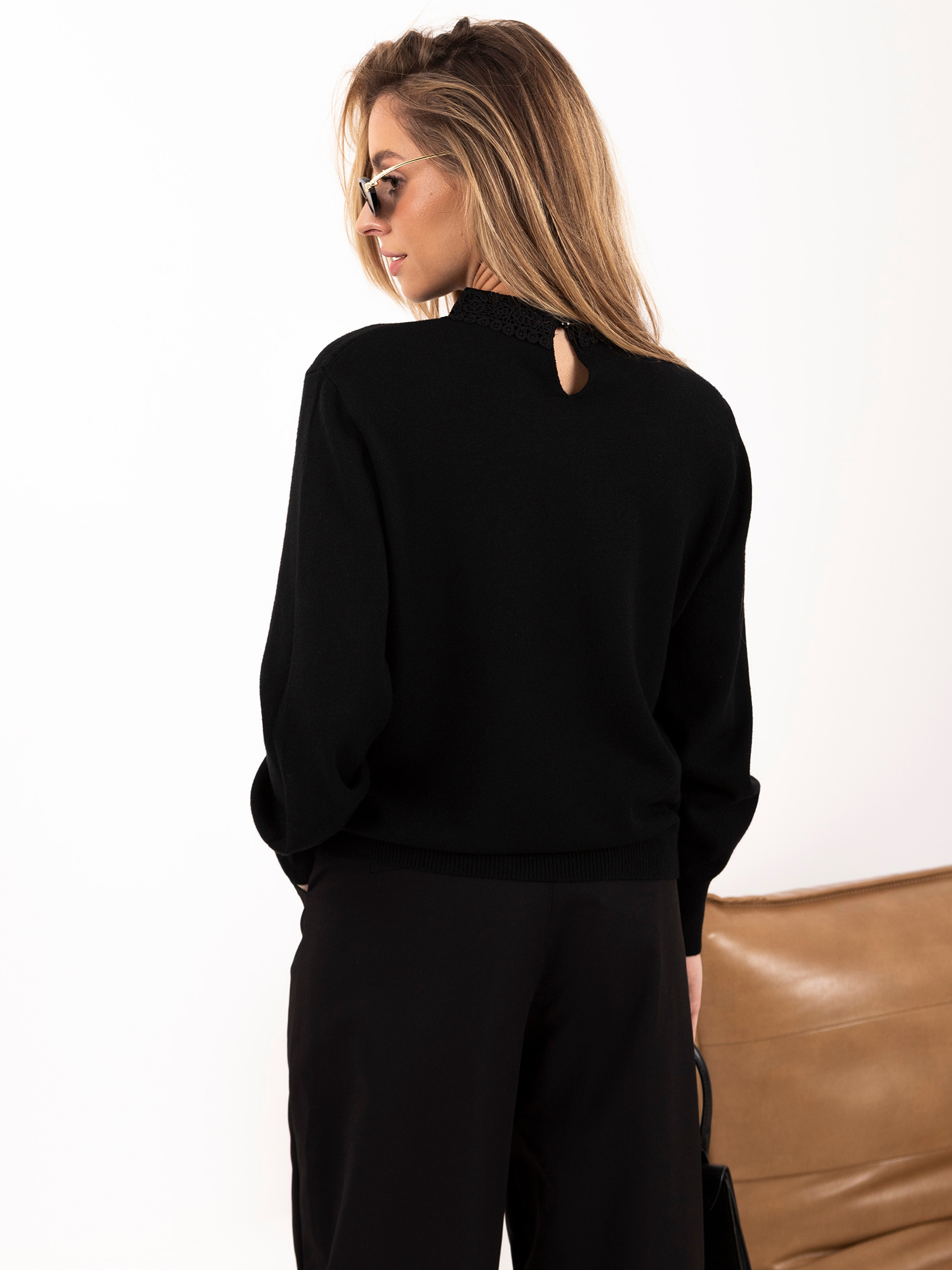 Schwarzer Damenpullover mit Spitzenkragen.