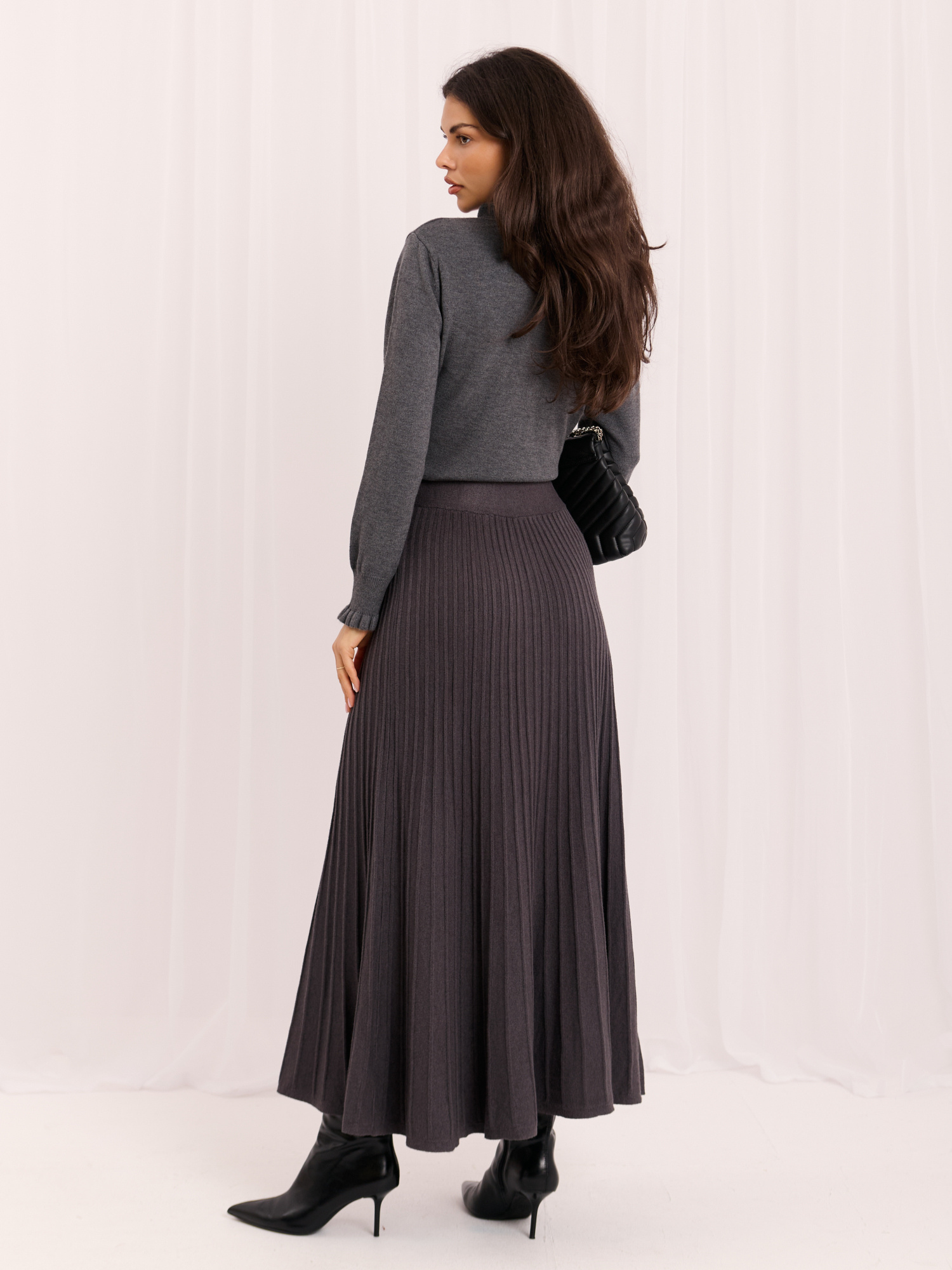 Dark gray knitted skirt with pleats.
