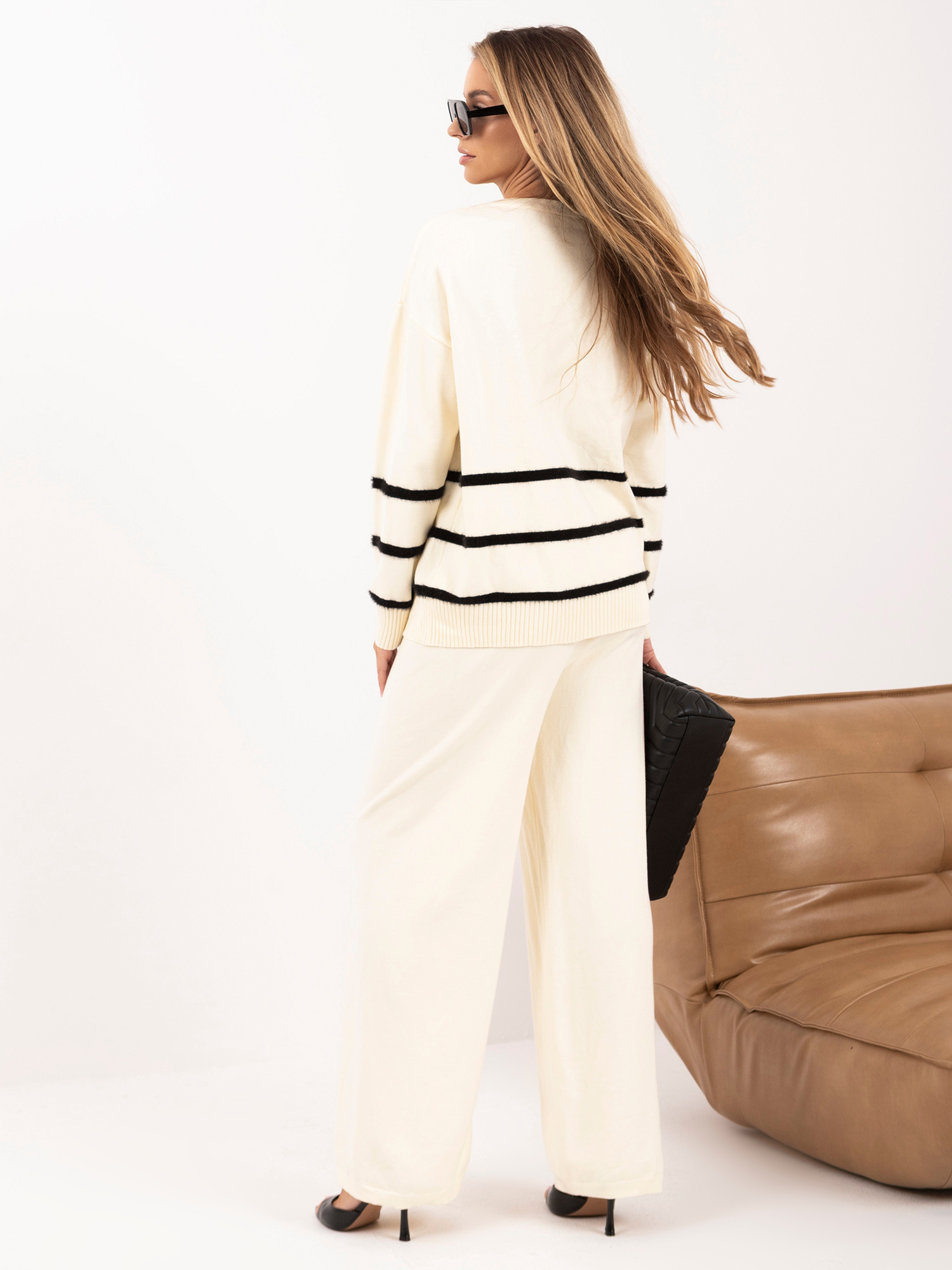 Helle beige Strickset mit gestreiftem Pullover.