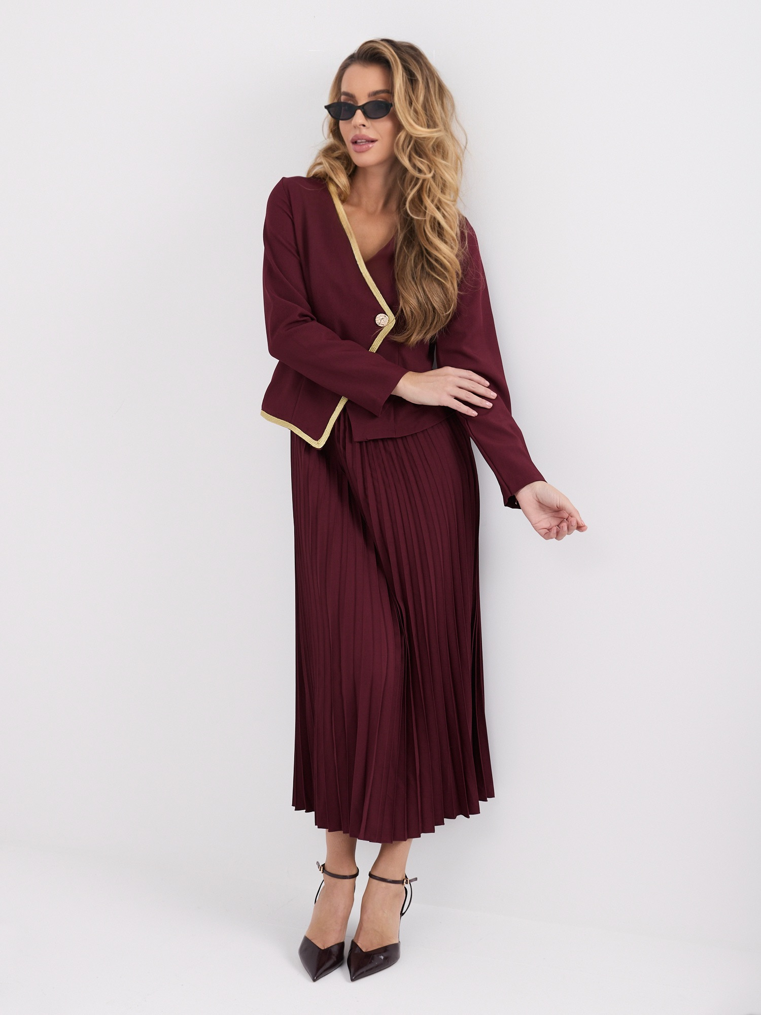 Bordeauxfarbendes plissiertes Kleid mit kontrastierendem Besatz.