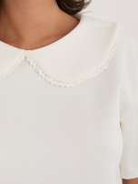Ecru women's blouse with a decorative collar.