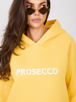 Geltona oversize bliuzono su užrašu prosecco RUE PARIS.