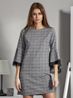 Schwarz-weiße gemusterte Kleid mit spanischen Ärmeln.