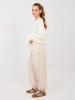 Jasnobeżowe dresowe spodnie z ozdobnym guzikiem