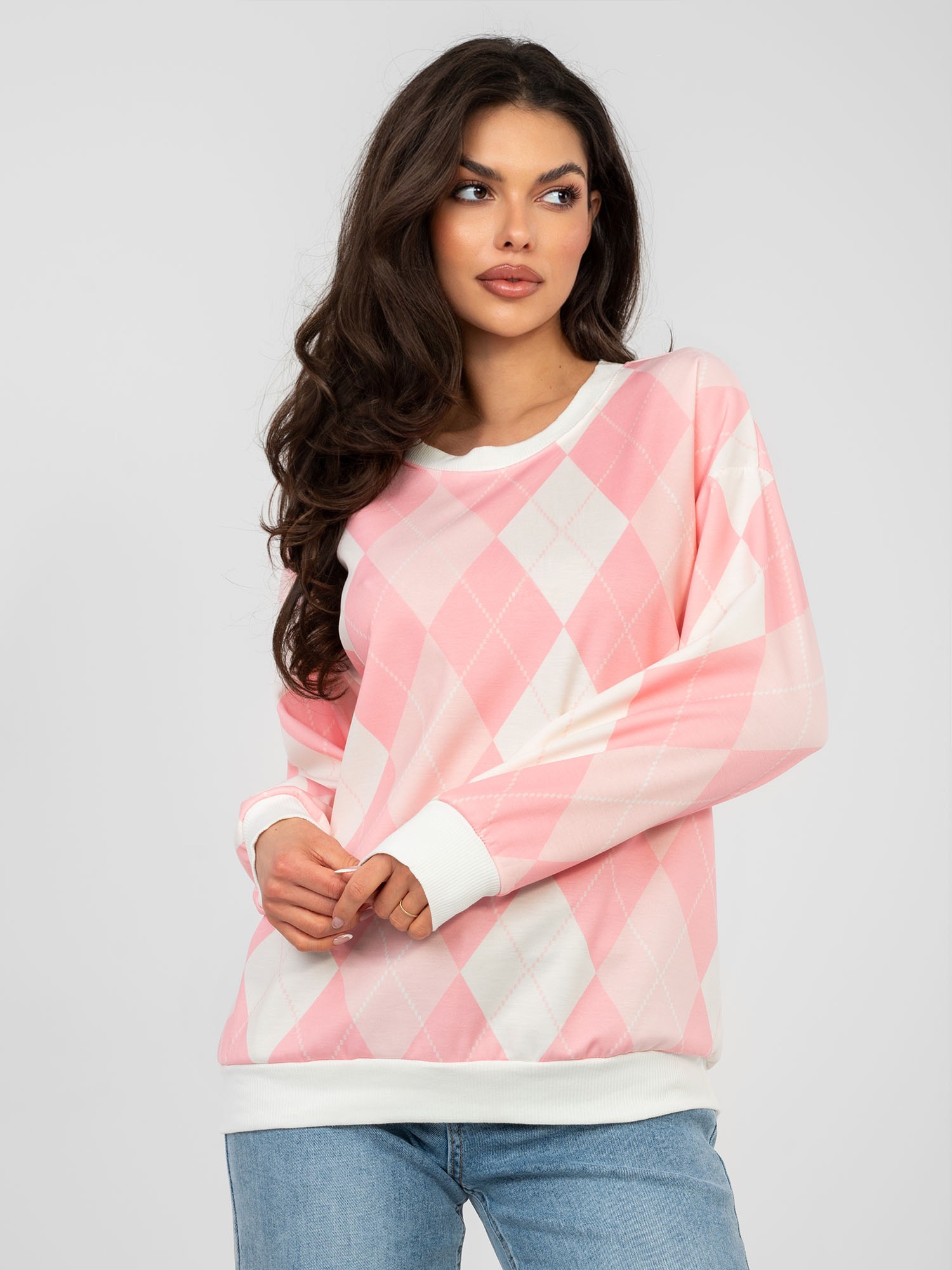 Pastellrosa Oversize-Pullover mit langen Ärmeln.