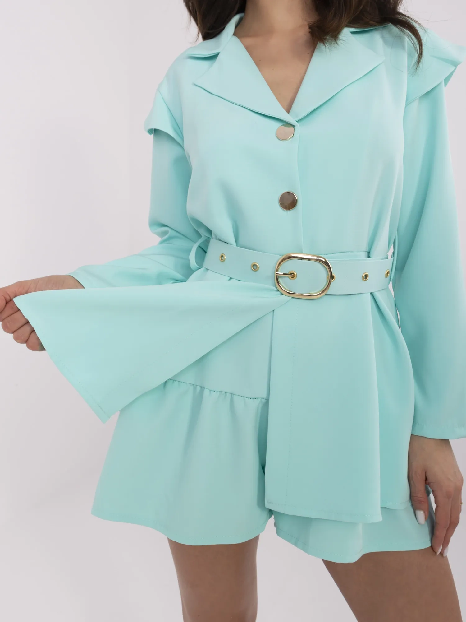 Mint short jumpsuit with button closure.