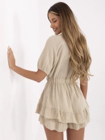 Beige muslin jumpsuit with ruffles.