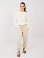 Jasnobeżowe dresowe spodnie z ozdobnym guzikiem