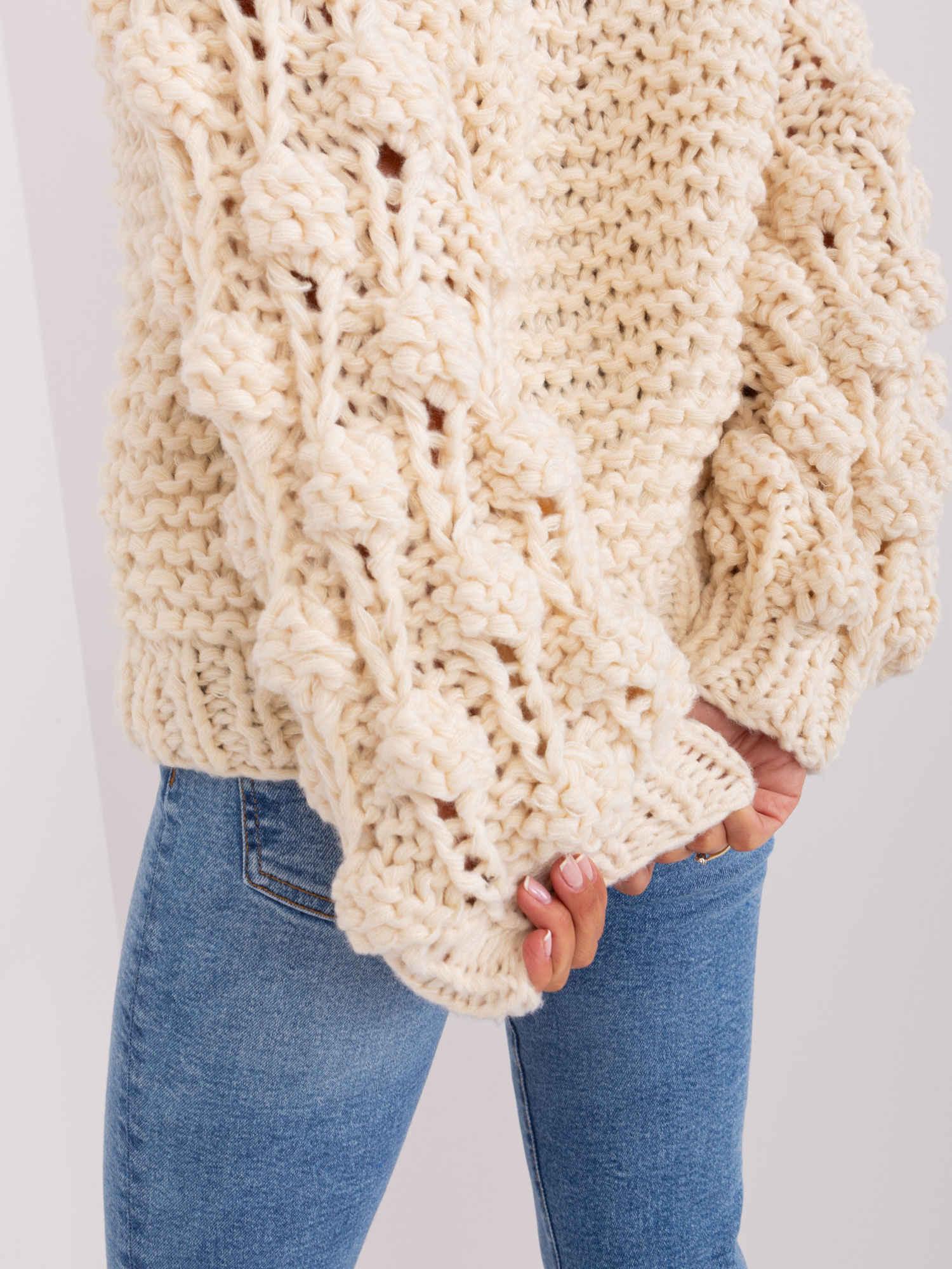 Jasnobeżowy sweter oversize z grubym splotem