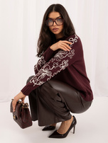 Bordeauxfarbener Pullover mit bestickten Ärmeln in Blumenmuster.