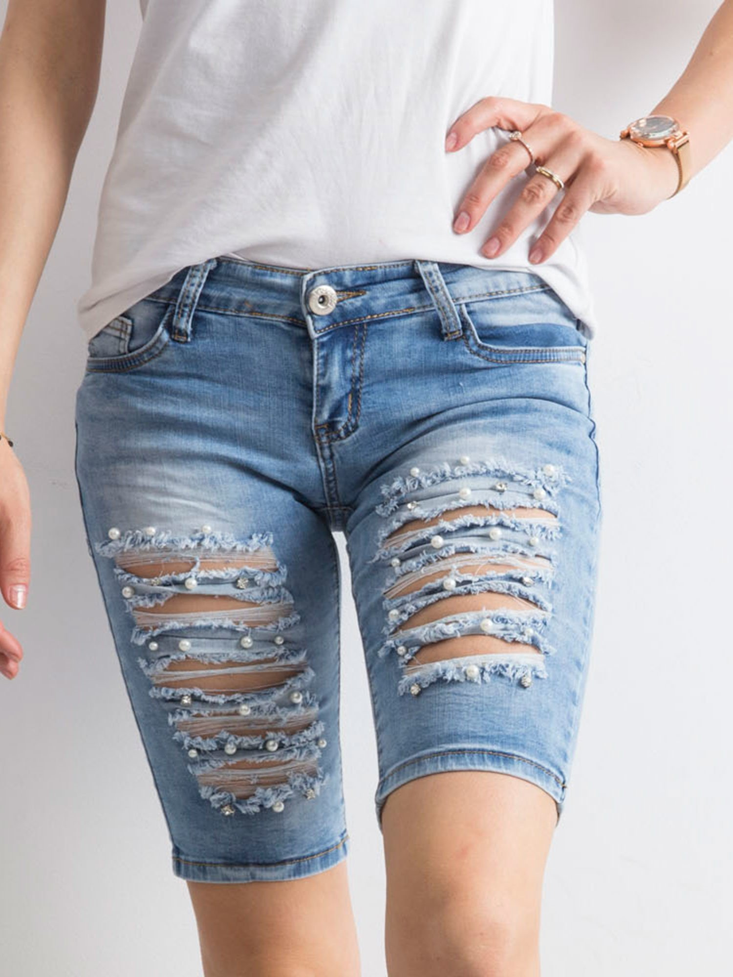 Blaue Jeans-Bermudas mit Löchern.