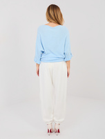 Ecru dresowe spodnie z kwiatową broszką