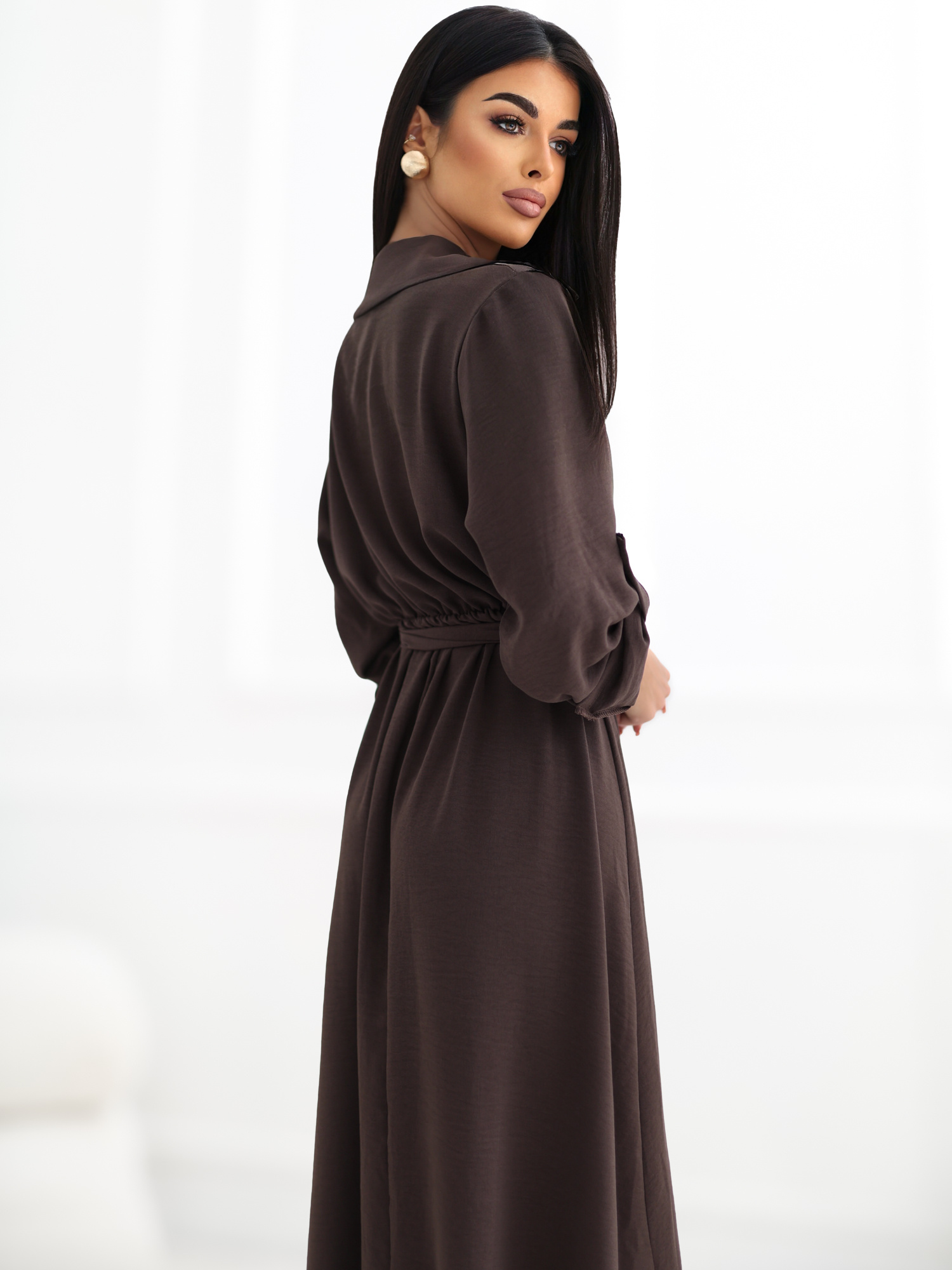 Brown shirt dress with decorative brooches.