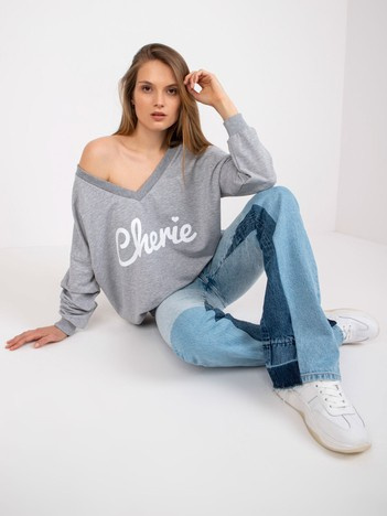 Grauweißer Oversize-Pullover mit Druck und V-Ausschnitt.