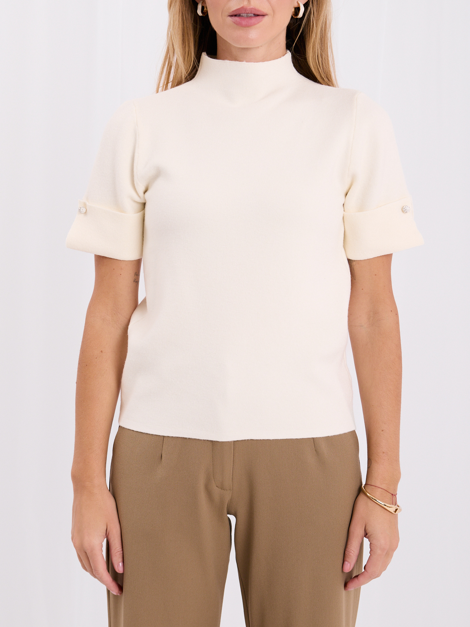 Ecru sweater with jewelry buttons on the cuffs.