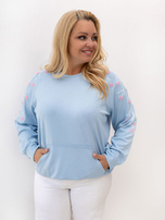 Svetlo modra majica plus size z cvetličnim aplikacijo.