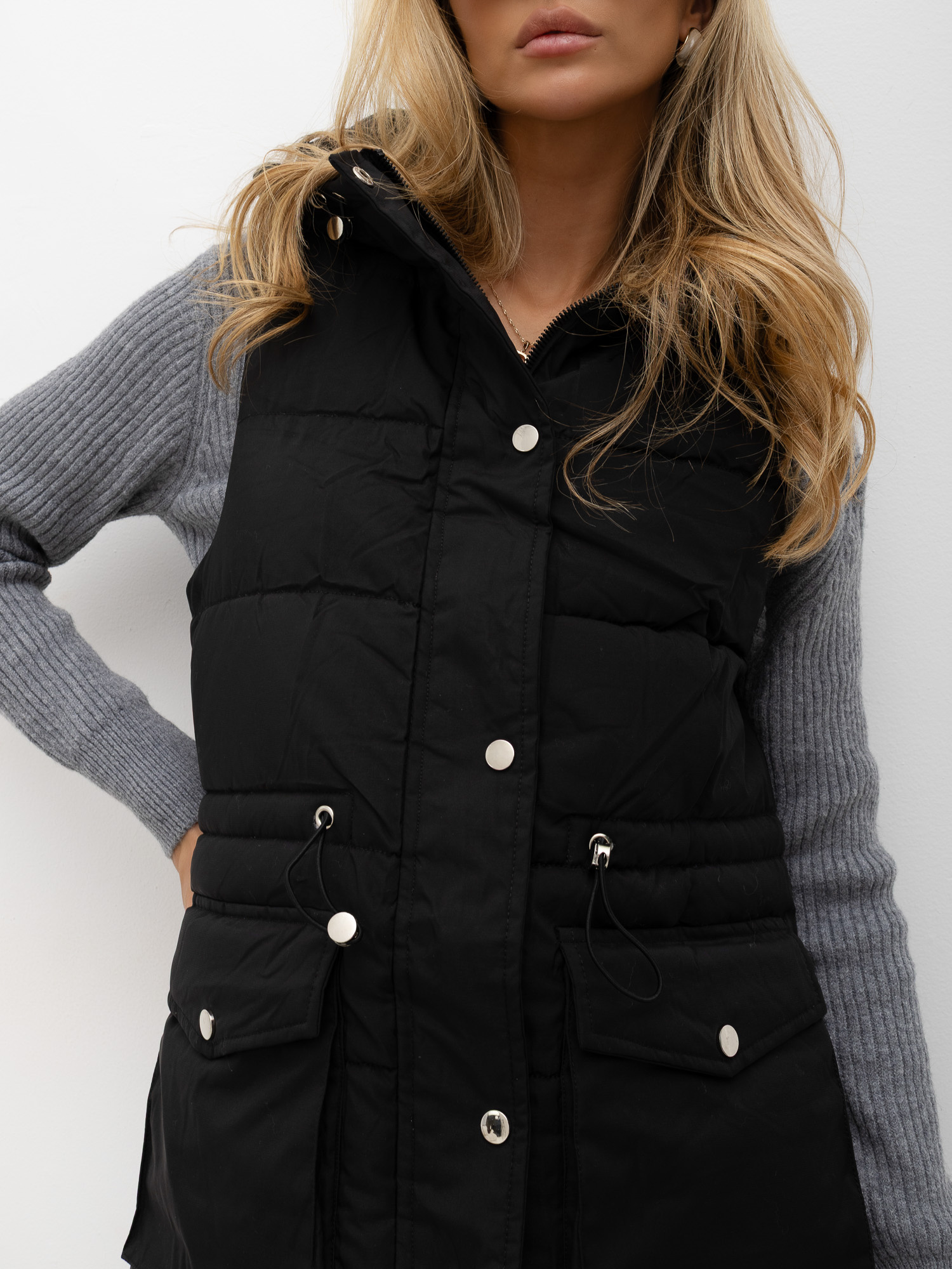 Černá prošívaná vesta s regulací v pase.