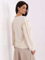 Light beige sweatshirt with puff sleeves.