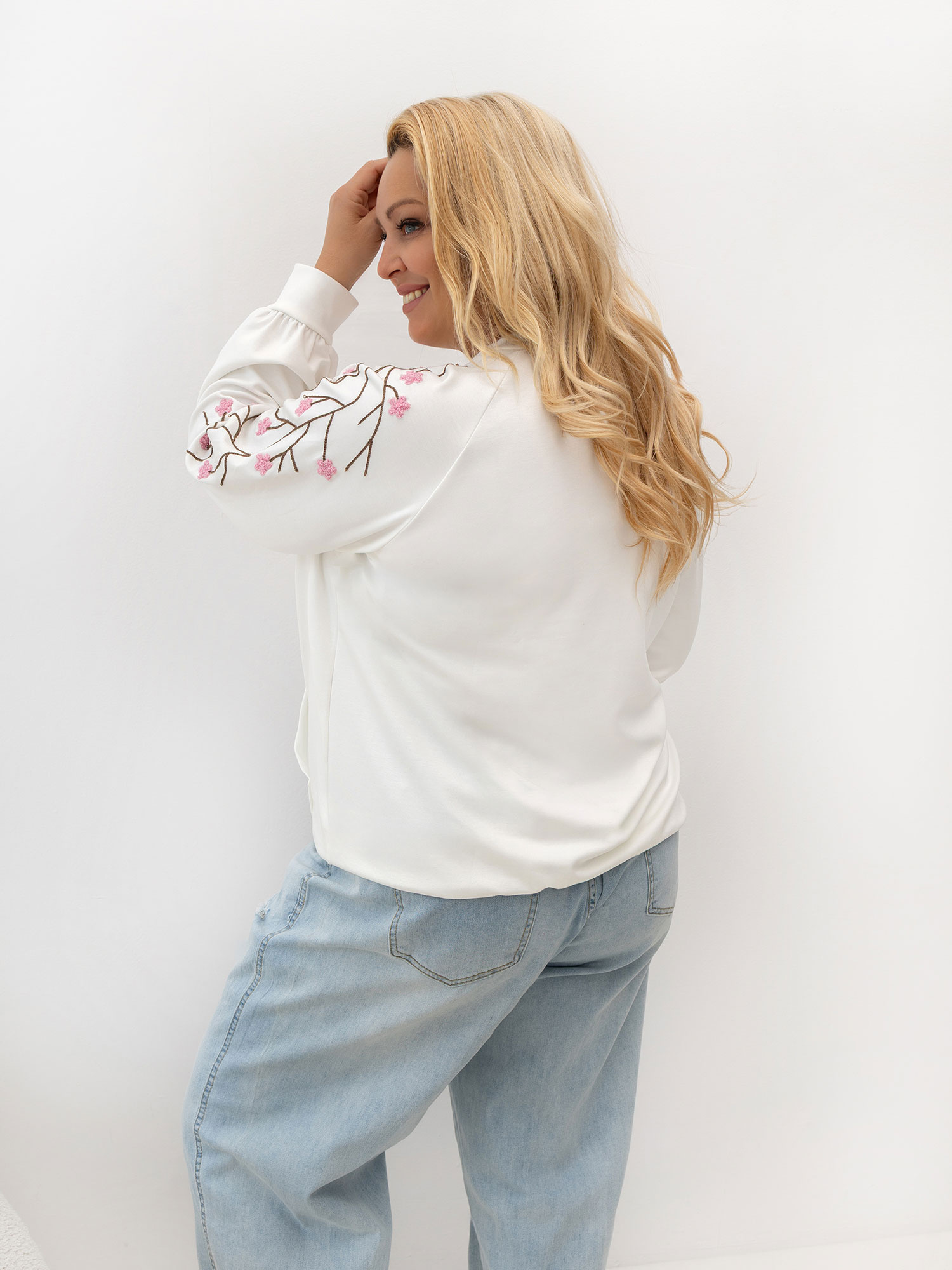 Bílá dámská mikina plus size s výšivkou na rukávech.
