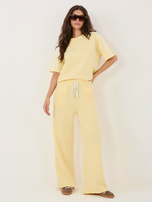 Jasnożółte dresowe spodnie z koronkowymi lampasami