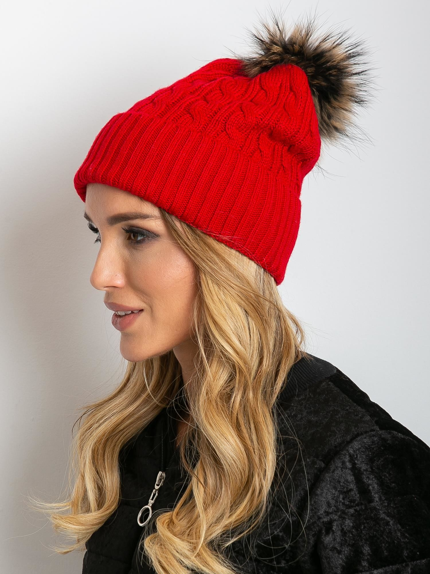 Rote Mütze mit Bündchen und felligem Pompon.