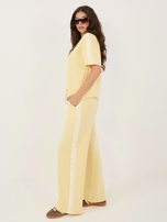 Jasnożółte dresowe spodnie z koronkowymi lampasami