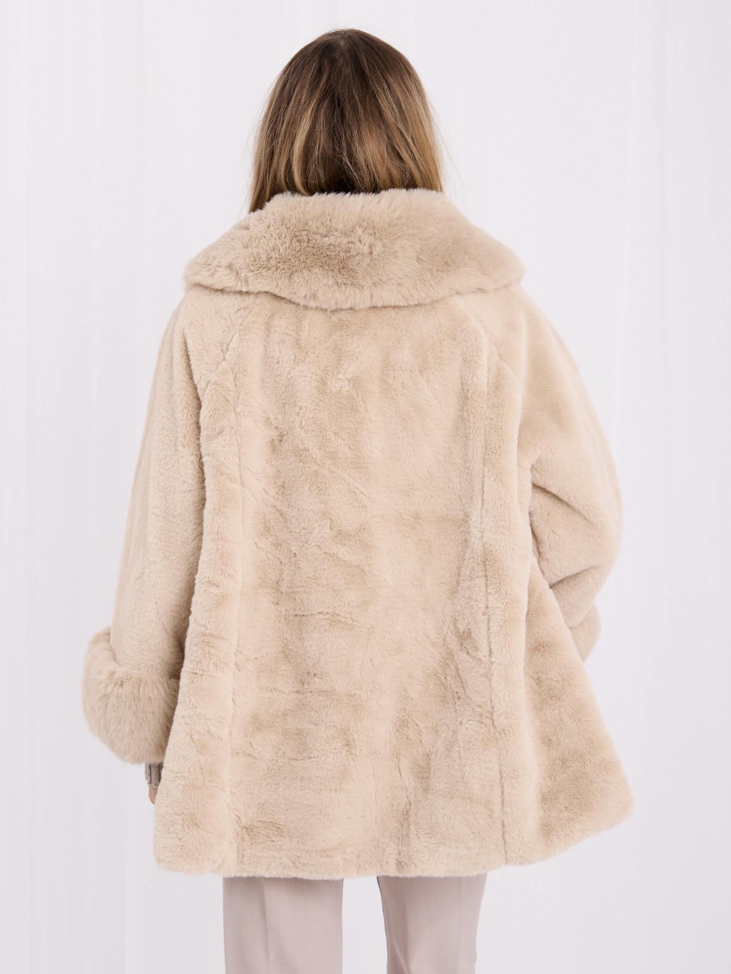 Light beige coat made of eco-fur with button closure.