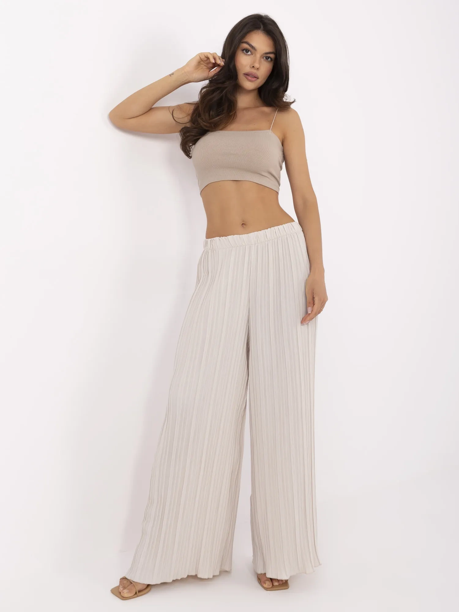 Beige wide trousers made of textured fabric.
