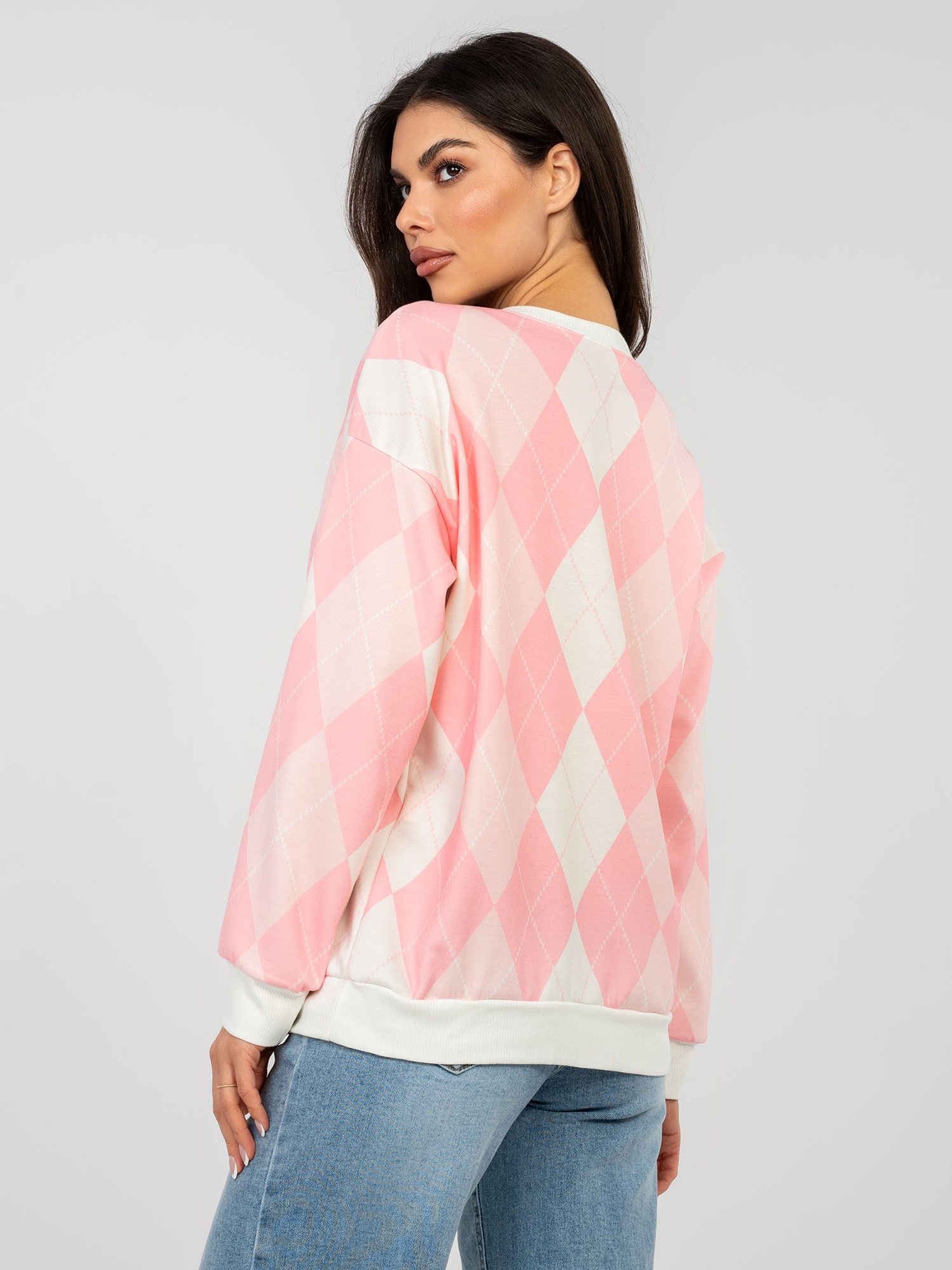 Pastellrosa Oversize-Pullover mit langen Ärmeln.