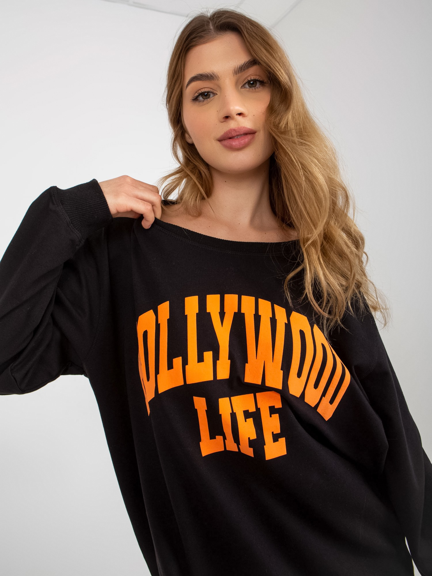 Juodai-oranžinė ilga oversize bliuzonė su užrašu.