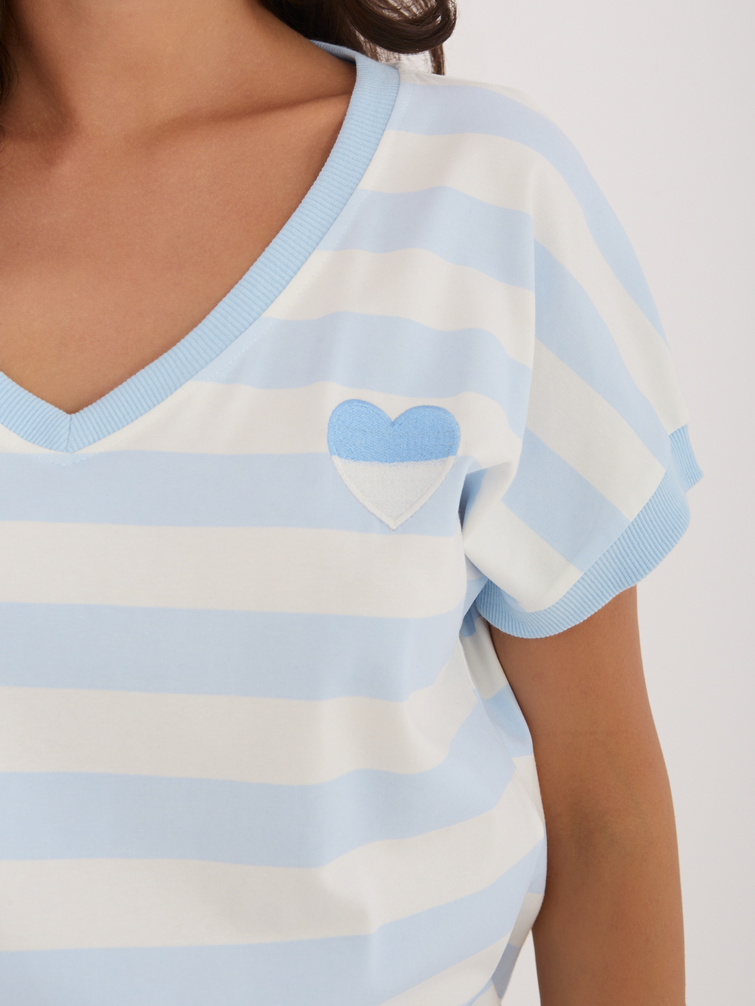 Light blue women's blouse with wide stripes.