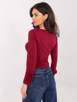 Bordeauxfarbige kurze Bluse mit langen Ärmeln.