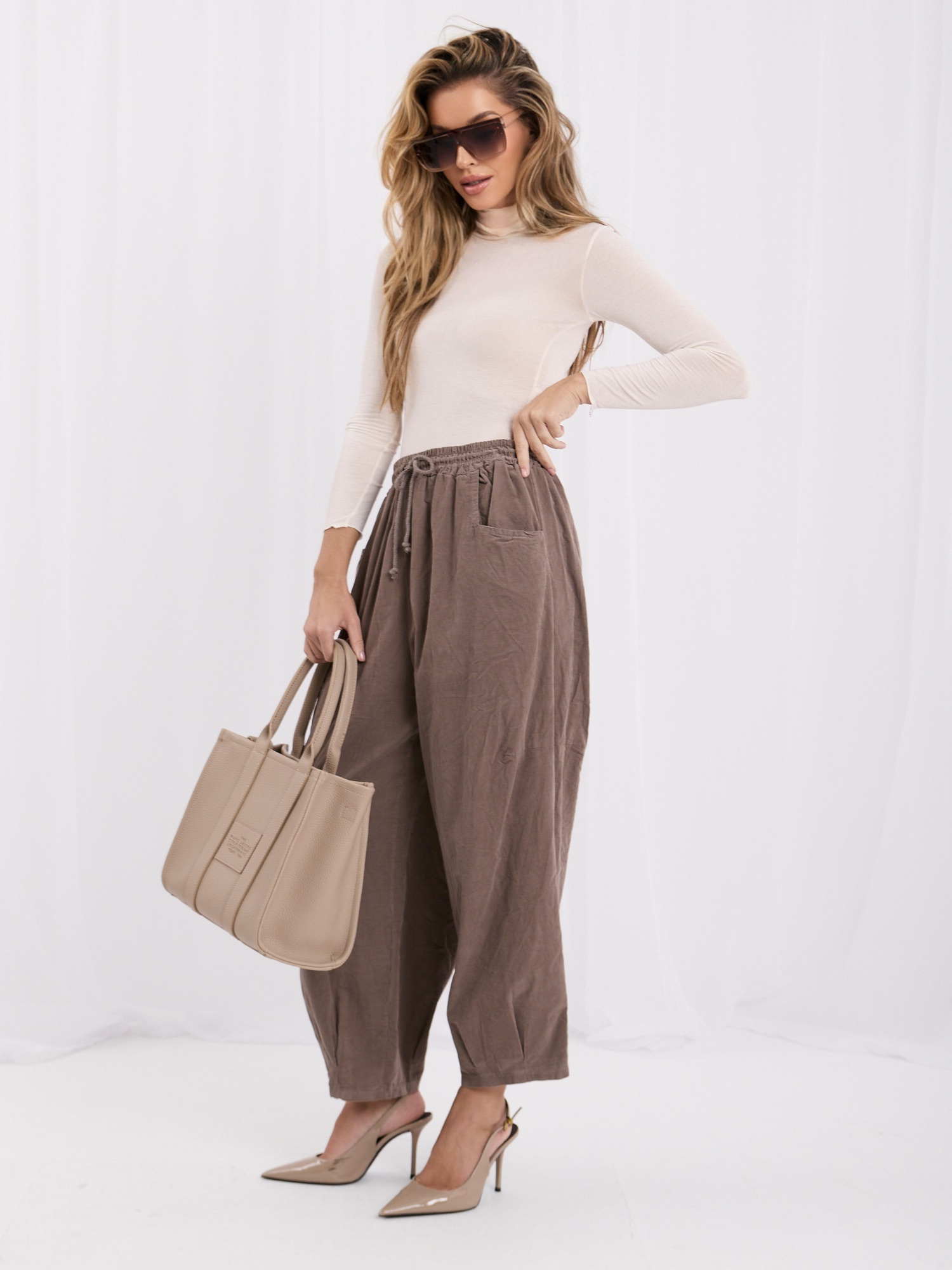 Dark beige corduroy trousers with pockets.