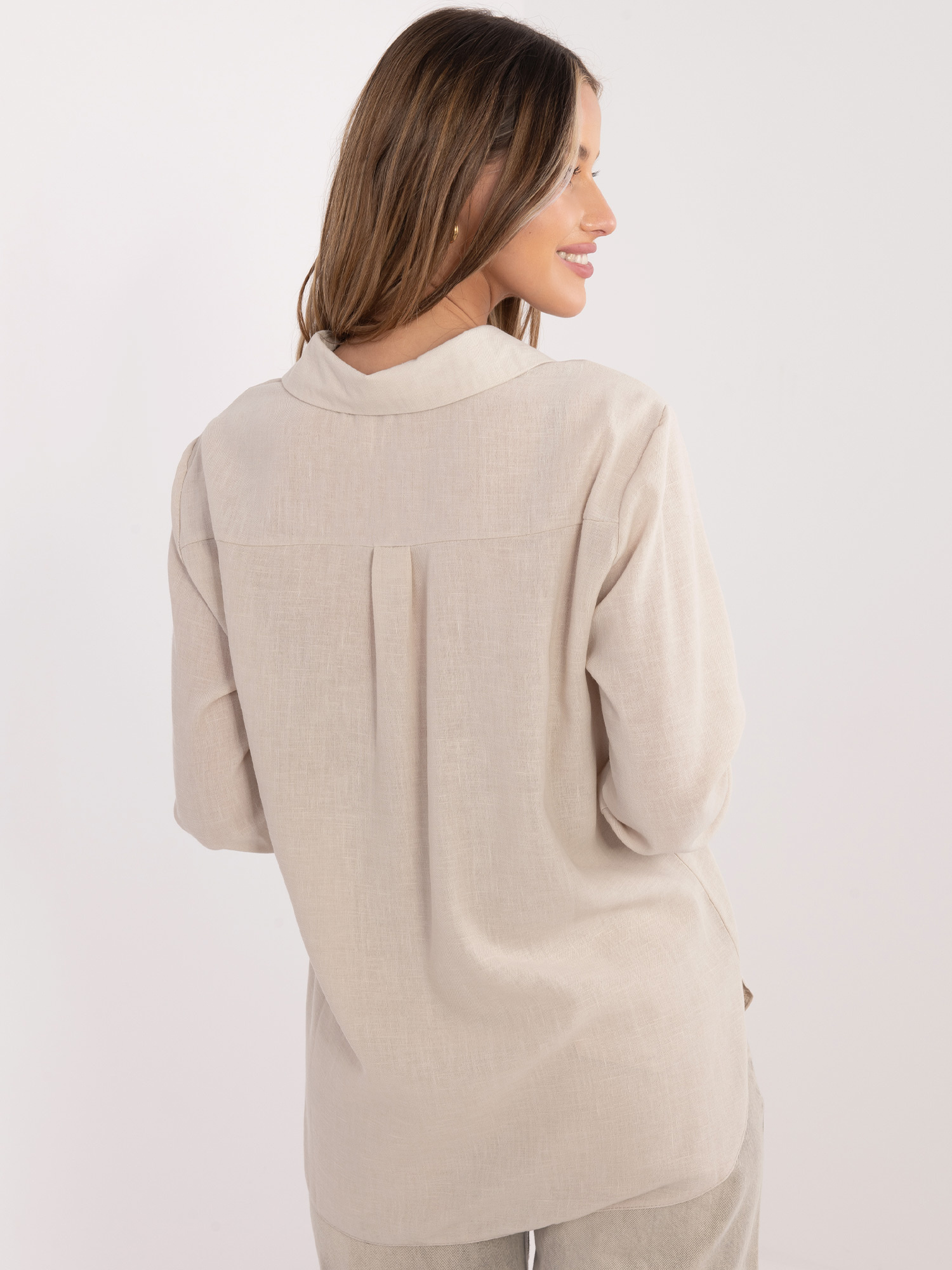 Beige Damenbluse mit längerem Rücken.