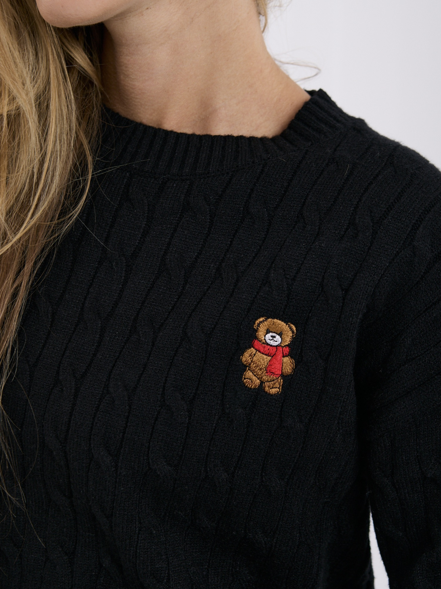 Black women's sweater with an embroidered bear.