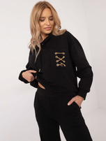 Schwarzes Sweatset mit dekorativen Ketten.