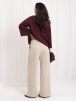 Beige Anzughose mit Falten.