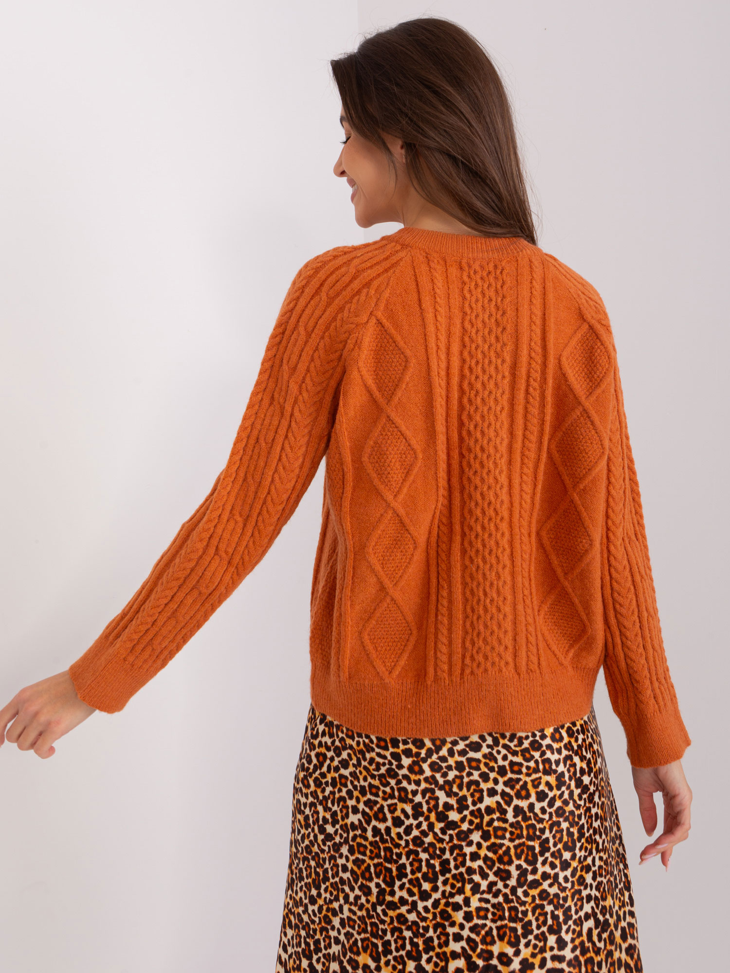 Ciemnopomarańczowy sweter rozpinany w warkocze