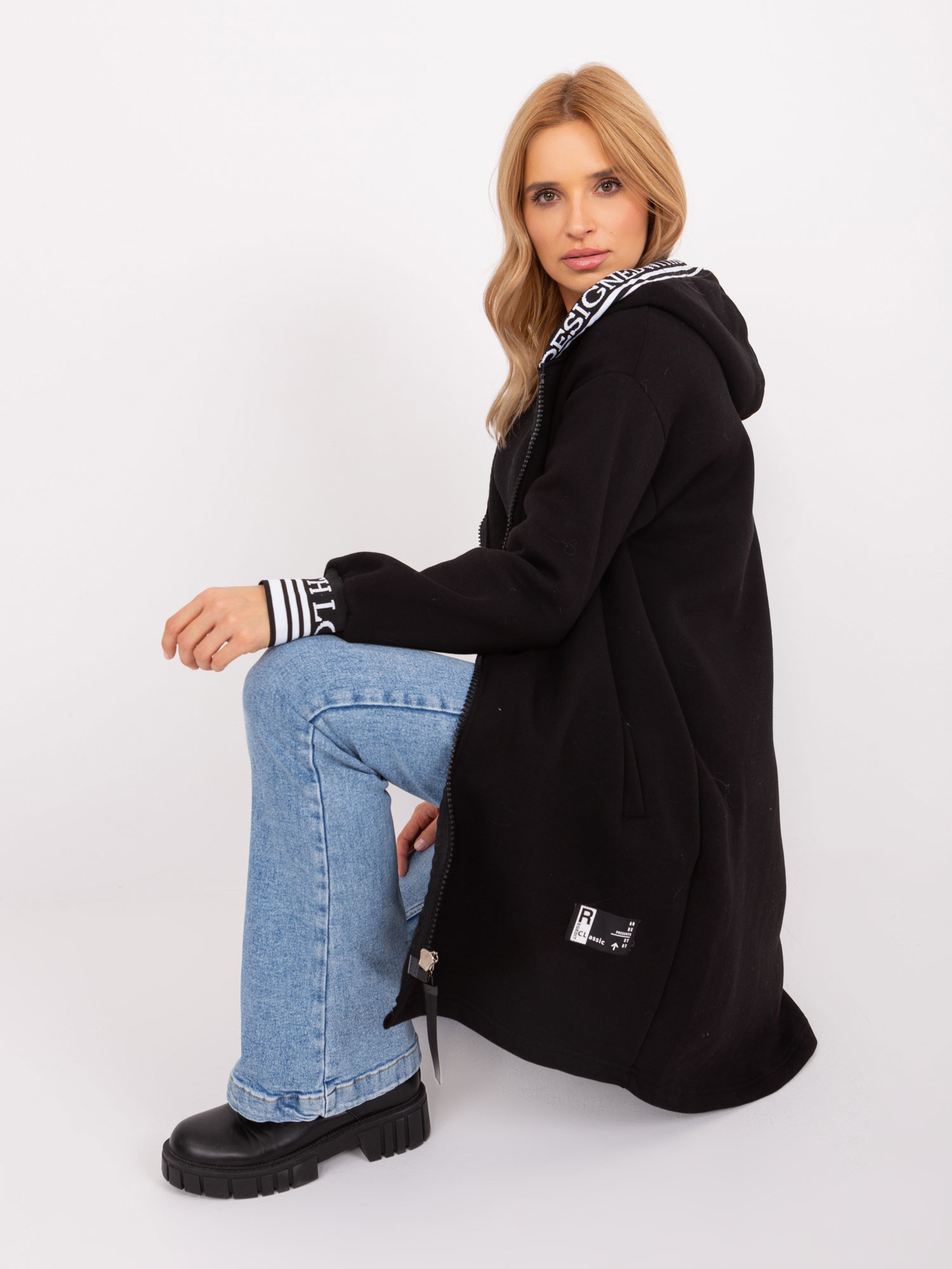 Juoda sportinė striukė su gobtuvu.